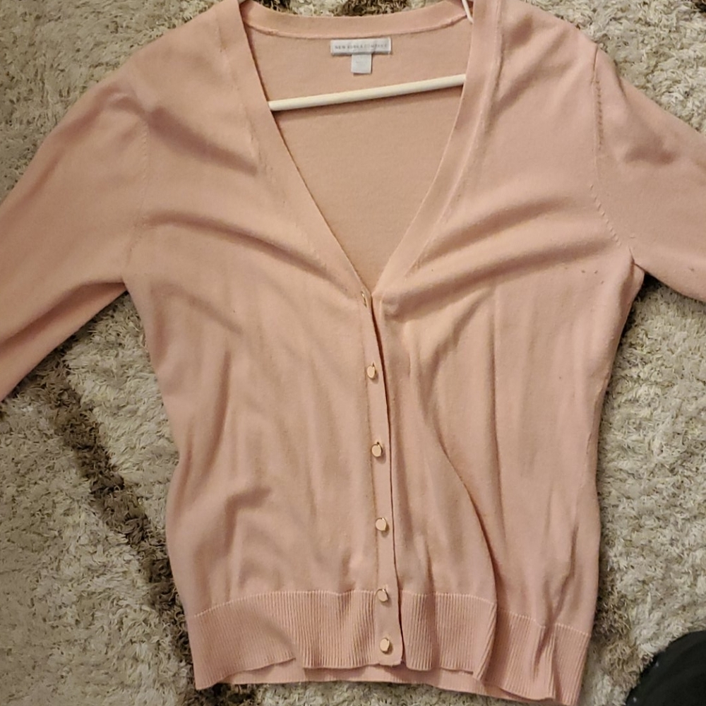 Pink button halfway up sweater